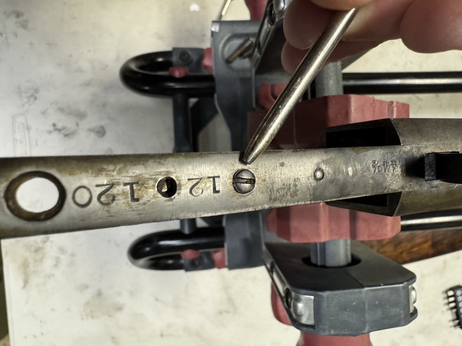 Pointer indicating the hammer tension screw on the lower tang of the Stevens 44½, with the serial 12120 and the 44½ model stamp visible